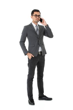 Sırıtarak, gözlük takım elbise giyen genç, yakışıklı, Asya, işadamı, tam uzunlukta portresi smartphone, söz heyecan ifade, izole beyaz zemin üzerine yumruk sıkılı