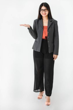 Tam uzunlukta stüdyo portre genç çekici Asyalı kadın, uzun siyah saçlı, gözlük, rahat moda, yüksek topuk, gülümseyen, kamera, izole beyaz zemin üzerine bakarak değil palm açın