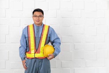 Orta Asya site mühendisi olarak tulum, portakal, Toplantı salonunun inşaat alanında, sarı güvenlik kask üzerinde koymak içinde sarı yansıtıcı Emanet yelek giyen yaşlı, varoluş hazırlamak dışarı çıkmak için