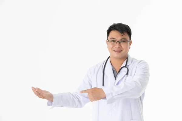 幸せな中年ハンサムなアジアの医者の半分の長さの肖像画は 眼鏡をかけて 彼の首の周りに聴診器を 手を差し出し 彼の右手の目に見えない商品を指し 孤立した白い背景に — ストック写真