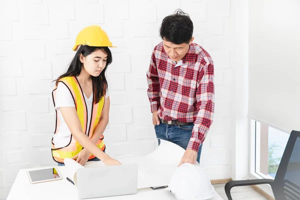 Orta yaşlı Asyalı, iş adamı, gözlüklü, beyaz tişörtlü, çalışma yerinde, ofisinde duruyor, gülümsüyor, memnun ve kendinden emin bir şekilde işe girişinden, ofis geçmişinden,