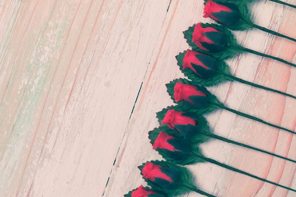 Valentine's day and Love concept, arrangement of beautiful fake red rose and leaf, orderly row on bright brown wooden background, copy space on bottom side, flat lay, top view greeting card style — Stock Image Valentine Day Love Concept Arrangement Beautiful Fake Red Rose Leaf Royalty Free Stock Images