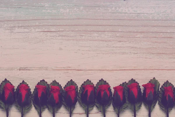 Valentine's day and Love concept, arrangement of beautiful fake red rose and leaf, orderly row on bright brown wooden background, copy space on bottom side, flat lay, top view greeting card style — Stock Image Valentine Day Love Concept Arrangement Beautiful Fake Red Rose Leaf Royalty Free Stock Images