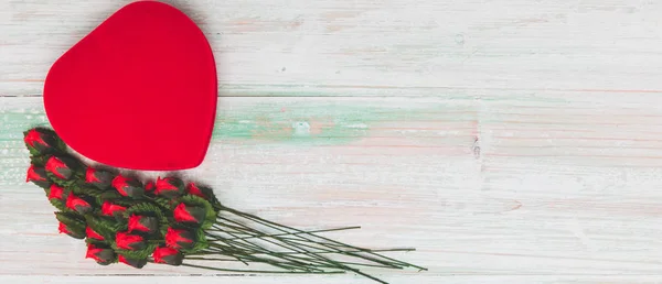 Valentine's day, Love, wedding concept, arrangement of beautiful fake red rose, leaf orderly stack with red heart shaped box on bright brown wooden background, copy space, flat lay, top view — Stock Image Valentine Day Love Wedding Concept Arrangement Beautiful Fake Red Rose Royalty Free Stock Images