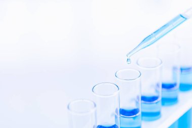 Birisi test tüpleri mavi sıvı bırakarak