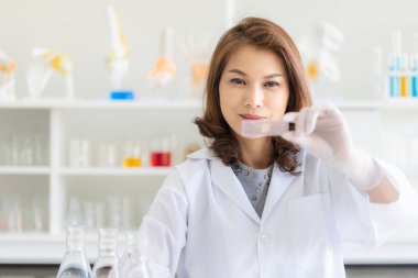 Asyalı kadın bilim adamı laboratuvarda poz veriyor