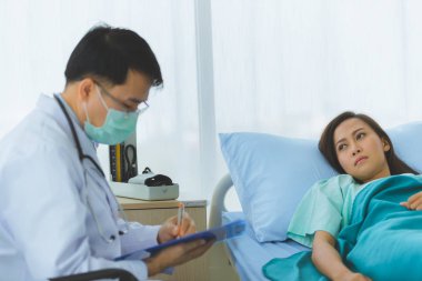 Doktor kadın hastanın nabzını tuttu..