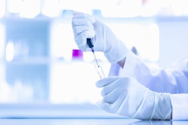 Birisi test tüpleri mavi sıvı bırakarak