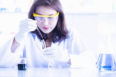 Bilim adamı test tüpü için mor sıvı bırakarak
