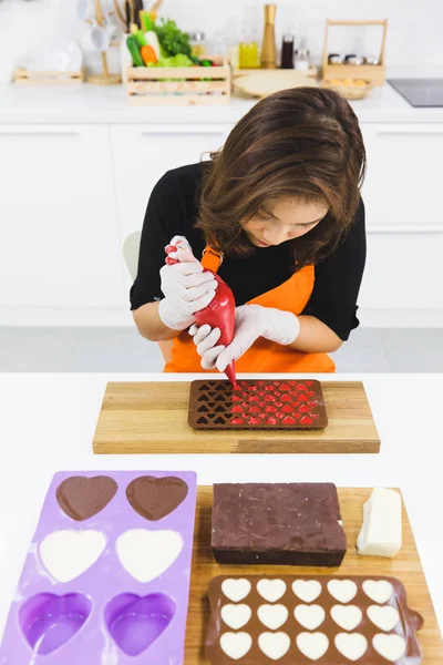 Kadın çikolata yapıyor.
