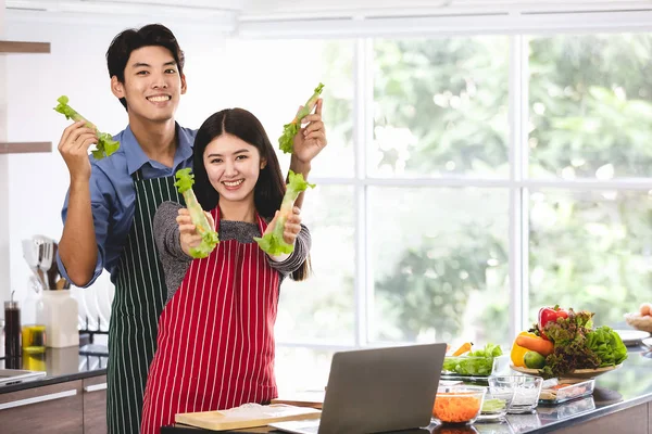 Casal em avental fazer rolos de salada juntos — Fotografia de Stock
