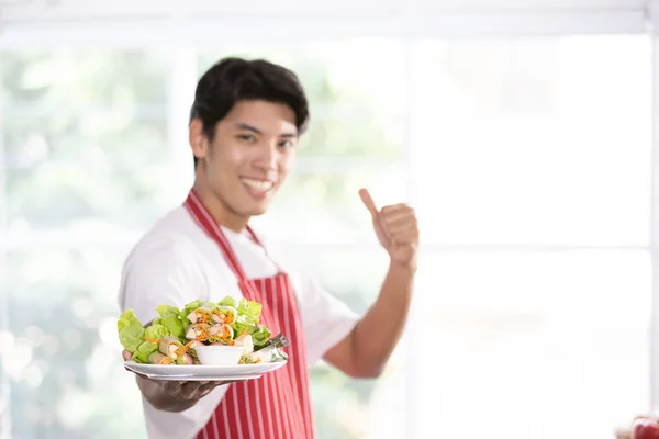 Asian man held a salad plate for the camera Royalty Free Stock Images