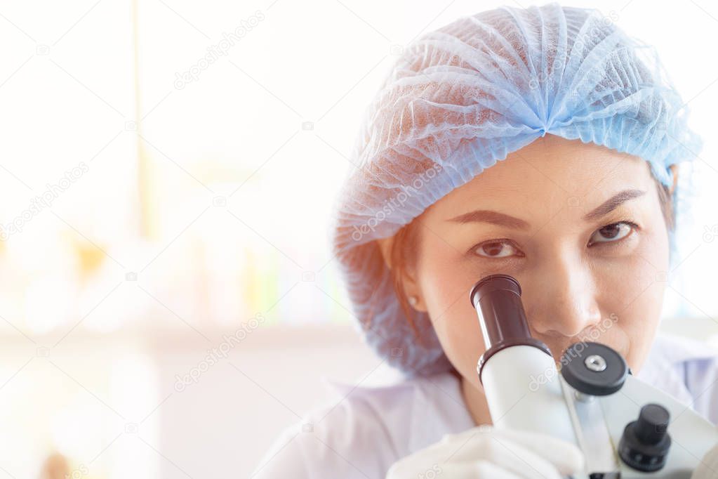 Scientist look throgh microscope