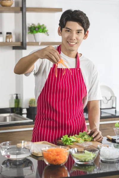 Asiático hombre, él cortar pepino en trozos pequeños —  Fotos de Stock