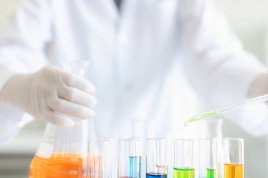 Bilim adamı test tüpü için yeşil sıvı bırakıyor