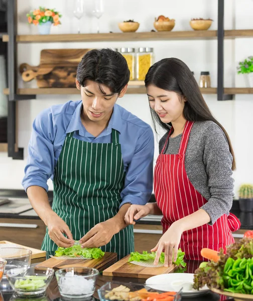 Asiático casal em avental fazer uma salada juntos — Fotografia de Stock