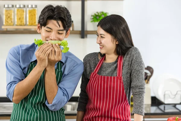 Casal em avental fazer rolos de salada juntos — Fotografia de Stock