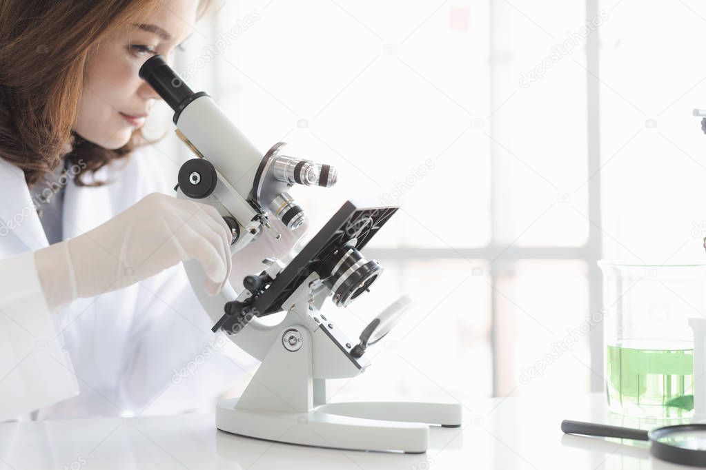 Asian scientist look throgh microscope