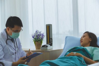 Asyalı doktor kadın hastanın hastalığı kontrol.