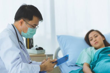 Doktor kadın hastanın nabzını tuttu..