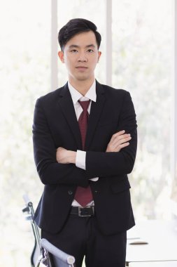 Asyalı İşadamı ofisinde duruyor ve poz veriyor