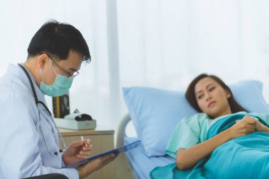 Doktor kadın hastanın nabzını tuttu..