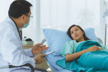 Doktor kadın hastanın nabzını tuttu..