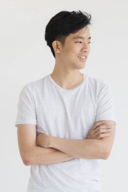 Young Asian man model in T-shirt crossed arm