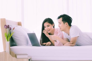 Asyalı çift yatak odasında yatar..