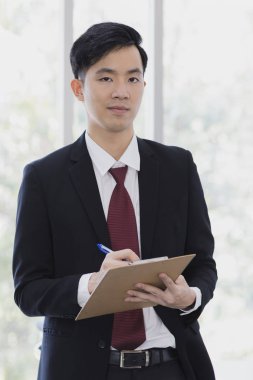 Asyalı İşadamı ofisinde duruyor ve poz veriyor