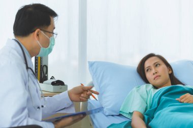 Doktor kadın hastanın nabzını tuttu..