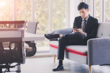 Ofiste cep telefonu kullanan Asyalı işadamı