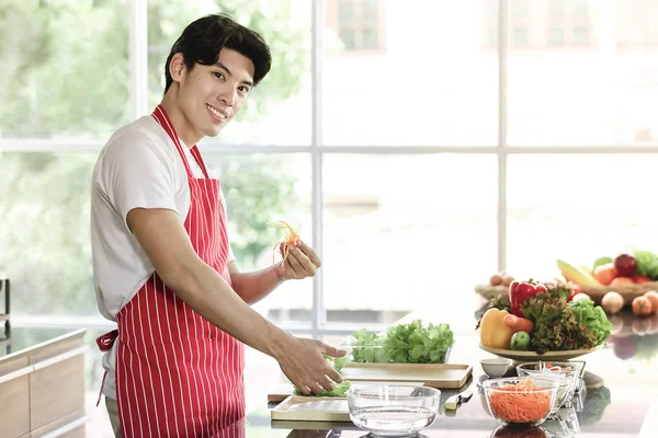 Homem asiático está preparando um prato de salada — Fotografia de Stock