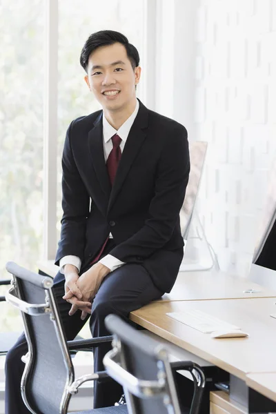 Азиатский бизнесмен сидит и позирует в офисе — стоковое фото
