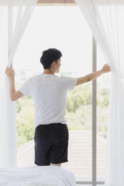 Ouvrez le rideau et regardez à l'extérieur de la fenêtre — Photo