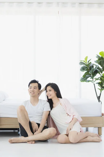 Sexy couple in pajamas sit on floor in bedroom — Stock Photo, Image