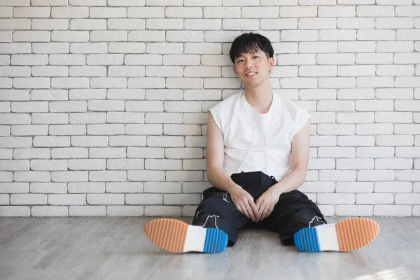 Ásia modelo homem sentado no chão e joelho até — Fotografia de Stock