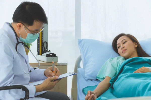 Asiático médico comprobar la enfermedad de mujer paciente . — Foto de Stock