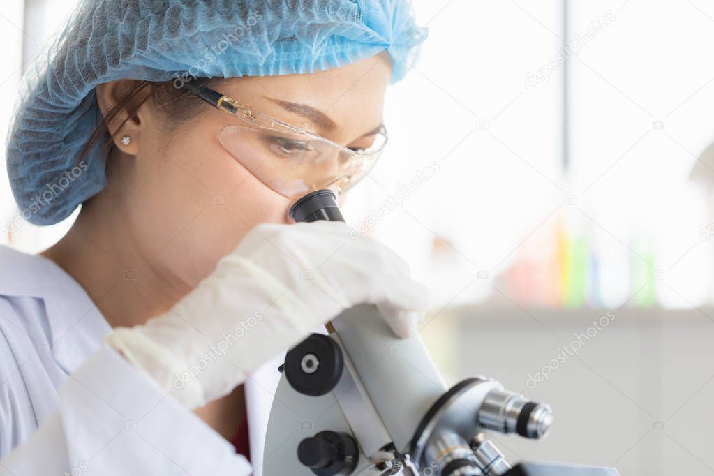Scientist look throgh microscope