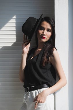 Asyalı kadın pencerede elini sıkar.