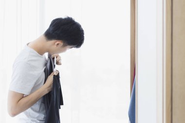 Adam dolaptan siyah bir tişört aldı.