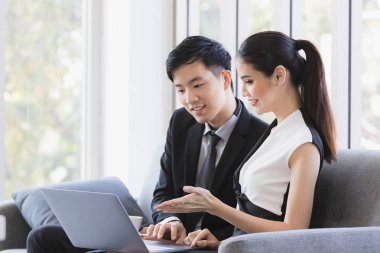 Ofiste dizüstü bilgisayar kullanan Asyalı işadamları