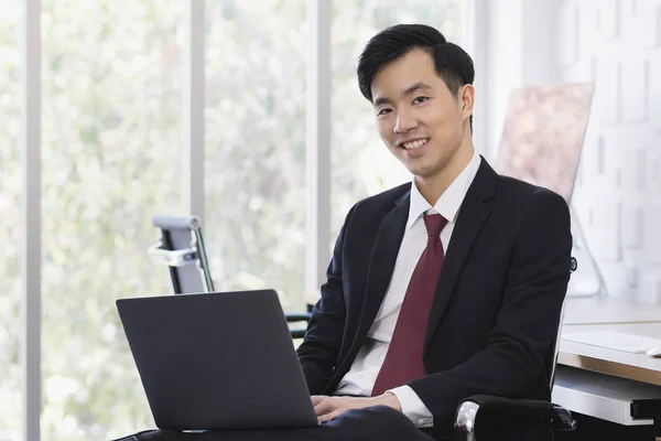 Азиатский бизнесмен использует ноутбук в офисе — стоковое фото
