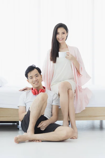 Sexy couple asiatique en pyjama assis dans la chambre — Photo