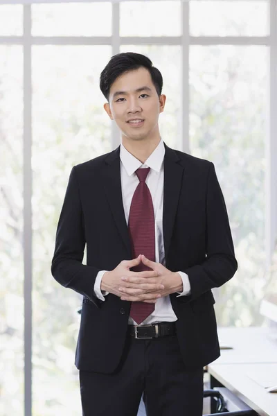 Азиатский бизнесмен, стоящий и позирующий в офисе — стоковое фото