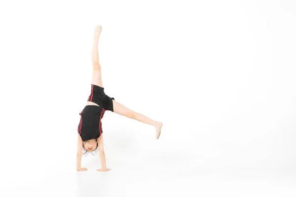 Азиатская девушка, стоящая и позирующая в гимнастической позе на белом фоне — стоковое фото