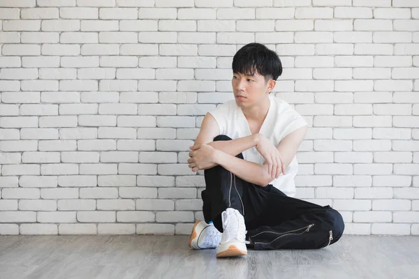 Ásia modelo homem sentado no chão e joelho até — Fotografia de Stock
