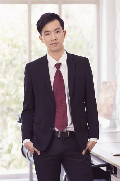 Aziatisch zakenman staan en poseren in het kantoor — Stockfoto