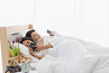 Kadın yatak odasında akıllı telefon kullanıyor.