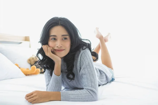 Wanita Asia menopang dan berbaring rawan di tempat tidur — Stok Foto